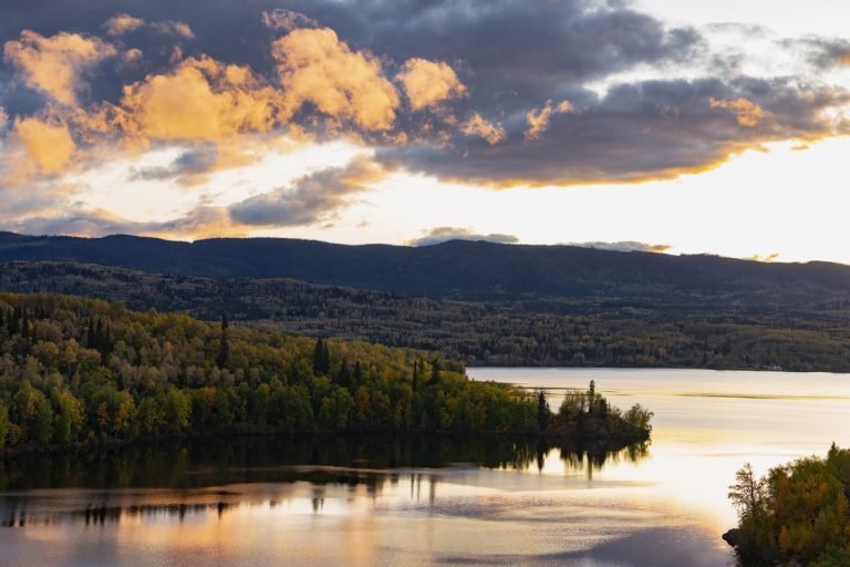 Burns Lake waterfront at dusk with forested shoreline